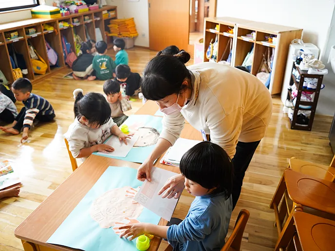先生が子どもたちと活動する後ろ姿